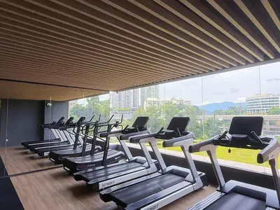 a row of treadmills in a gym with a large window at 2BR with Balcony High Floor, Henna Residence Near LRT Sri Rampai & Wangsa Walk Mall in Kuala Lumpur