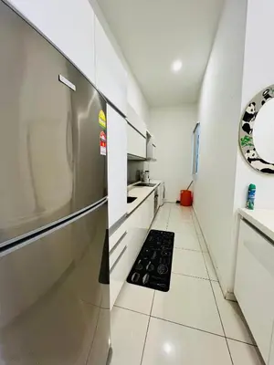 a kitchen with a refrigerator and a tile floor at M City by Celestia Suites in Kuala Lumpur