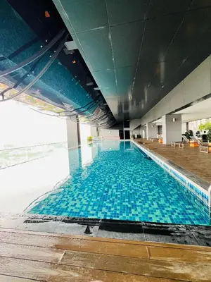 a large swimming pool with blue tiles in a building at M City by Celestia Suites in Kuala Lumpur