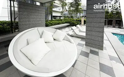 a white couch with pillows sitting on a patio at MET 1 Residences Mont Kiara by Airhost in Kuala Lumpur