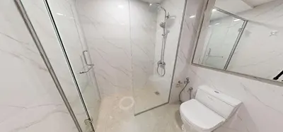 a bathroom with a shower and a toilet and a mirror at SOHO Suites KLCC by noon in Kuala Lumpur