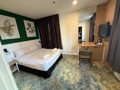 a bedroom with a bed and a desk and a television at Asto Hotel Kuala Lumpur in Kuala Lumpur
