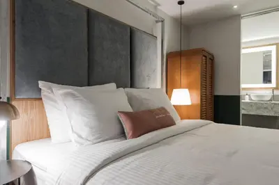 a bedroom with a large bed with white pillows at Swing & Pillows - Kentomen Hotel, Bamboo Hills in Kuala Lumpur