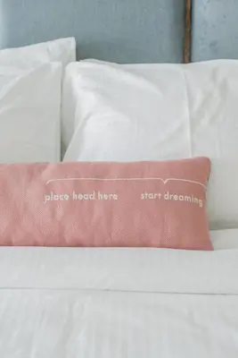 a pink pillow sitting on top of a white bed at Swing & Pillows - Kentomen Hotel, Bamboo Hills in Kuala Lumpur