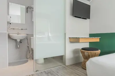 a bathroom with a sink and a toilet and a television at Swing & Pillows - Kentomen Hotel, Bamboo Hills in Kuala Lumpur