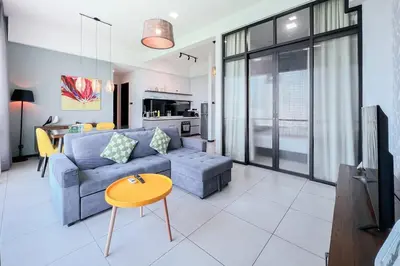 a living room with a blue couch and a table at Contemporary Apartment KL with 3 Bedrooms in Kuala Lumpur