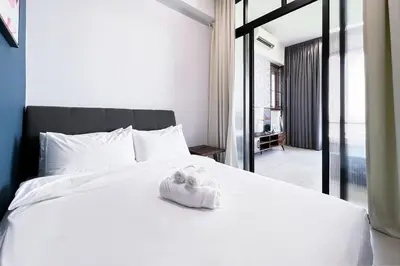 a white bed with a pair of shoes on it at Contemporary Apartment KL with 3 Bedrooms in Kuala Lumpur