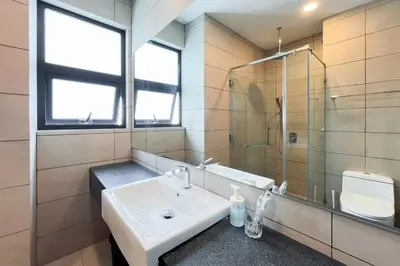 a bathroom with a sink and a glass shower at Contemporary Apartment KL with 3 Bedrooms in Kuala Lumpur