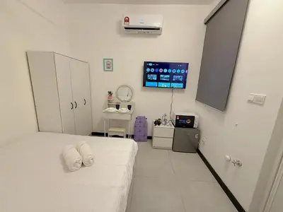 a room with a bed and a tv on the wall at Cozy unit By Rasbo Galaxy with LRT , Pool , KLCC in Kuala Lumpur