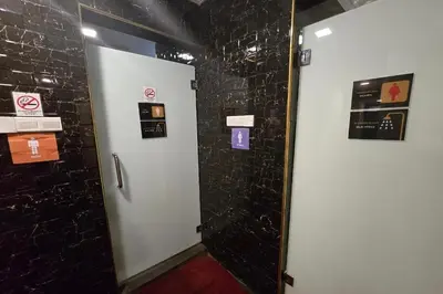 a bathroom with a black wall with signs on it at Hotel AL Amin in Kuala Lumpur