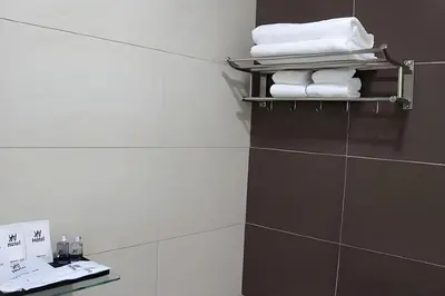 a bathroom with white towels on a shelf at Hotel AL Amin in Kuala Lumpur
