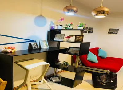 a desk and a red chair in a room at Taragon Puteri Bintang KLCC View Studio Apartment in Kuala Lumpur