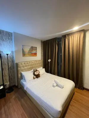 a teddy bear sitting on a bed in a bedroom at Taragon Puteri Bintang KLCC View Studio Apartment in Kuala Lumpur