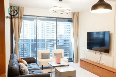 a living room with a couch and a large window at Eaton Residence City Suites in Kuala Lumpur