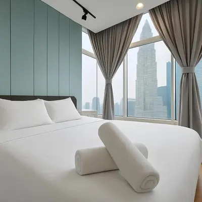 a white bed in a room with large windows at Kuala Lumpur Sky Suites KLCC in Kuala Lumpur