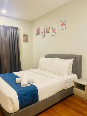 a bedroom with a large bed with a blue blanket at Kuala Lumpur Sky Suites KLCC in Kuala Lumpur