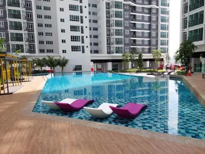 two pink and white chairs sitting next to a swimming pool at RSJ Homestay at Setapak - 2 Room in Kuala Lumpur