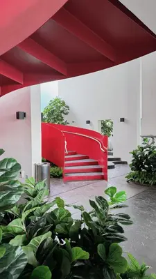 a red wall in a building with green plants at M Arisa Sentul City View Condo in Kuala Lumpur