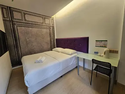 a small bedroom with a bed and a desk at VG Homes in Kuala Lumpur