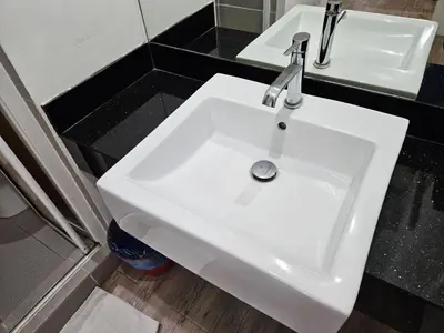 a white sink in a bathroom with two mirrors at VG Homes in Kuala Lumpur