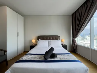 a bedroom with a large bed with a large window at Vortex Suites KLCC By GuestHouse in Kuala Lumpur