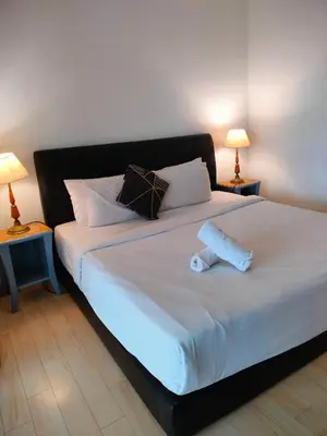 a bedroom with a large white bed with two lamps at Glacier suite at times square kl in Kuala Lumpur