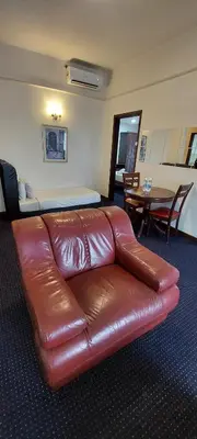 a brown leather couch in a room with a table at KL Heart Suite at berjaya Times Square in Kuala Lumpur