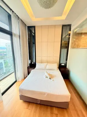 a bed in a room with a large window at Dorsett Luxury KLCC by IHG in Kuala Lumpur