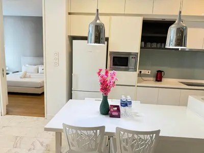 a kitchen with a white table with a vase of flowers at The Platinum KLCC By Elegant Suites in Kuala Lumpur
