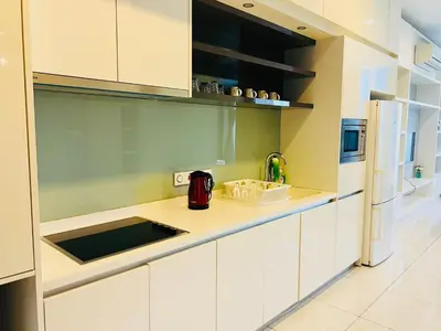 a kitchen with white cabinets and a white refrigerator at The Platinum KLCC By Elegant Suites in Kuala Lumpur