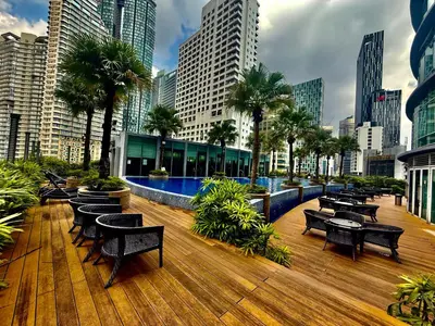 a deck with tables and benches in a city at Vortex Suites Klcc By Bukit Bintang in Kuala Lumpur