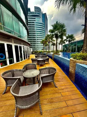 a deck with tables and chairs on a building at Vortex Suites Klcc By Bukit Bintang in Kuala Lumpur