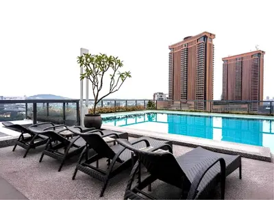 a hotel patio with chairs and a swimming pool at Bintang Fairlane Residence, 1 Min to Pavilion KL, Spacious Fam Suite 2B2R in Kuala Lumpur