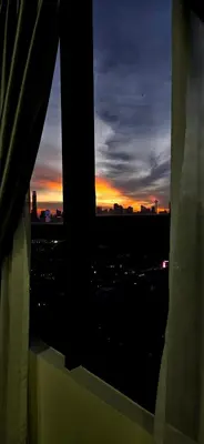 a view of a sunset from a window of a city at KLCC City View Retreat Cozy Spacious Apartment 2BR 2BTH in Kuala Lumpur