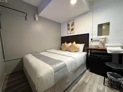 a bedroom with a bed and a desk with a phone at SS Grey House Bukit Bintang KL in Kuala Lumpur