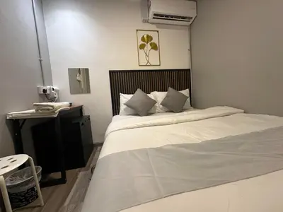 a bedroom with a large white bed and a telephone at SS Grey House Bukit Bintang KL in Kuala Lumpur