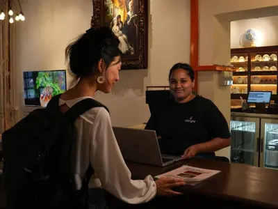 a man and a woman standing at a counter with a laptop at Mingle Lekiu in Kuala Lumpur