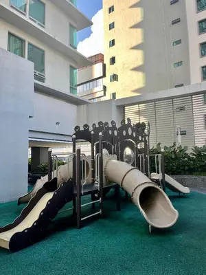a group of slides on a playground in front of a building at Stay Haven at Swiss Garden in Kuala Lumpur