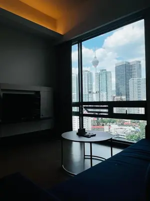 a room with a bed and a large window with a table at Stay Haven at Swiss Garden in Kuala Lumpur