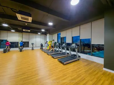 a gym with a row of treadmills and people exercising at 2R2B Velocity TWO KLCC TRX Sunway Medical LaGente in Kuala Lumpur