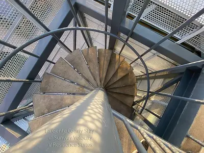 a spiral staircase in a building with a blue ceiling at La Gente Comfy Stay 2R2B Velocity - KL City View in Kuala Lumpur