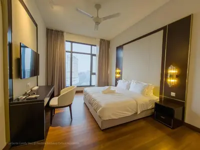 a hotel room with a bed and a desk and a television at 4R3B Luxe KLCC Embassy Pavilion 600MBPS Gas cook in Kuala Lumpur