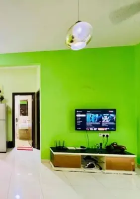 a green wall in a living room with a tv at REGALIA RESIDENCE KLCC VIEW INFINITY POOL by BT RZQNA in Kuala Lumpur