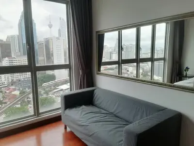 a living room with a couch and large windows at REGALIA RESIDENCE KLCC VIEW INFINITY POOL by BT RZQNA in Kuala Lumpur