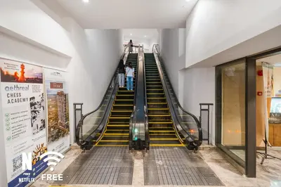 an escalator in a building with people on it at OOAK 2BR - Mont Kiara Garden international school in Kuala Lumpur