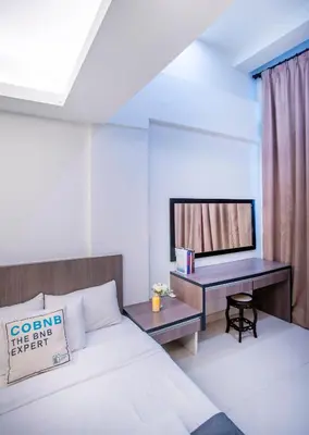 a bedroom with a bed and a desk with a television at Carlton, Chelsea by COBNB, Sri Hartamas, Kuala Lumpur in Kuala Lumpur