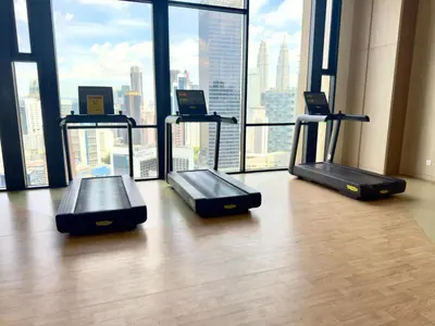a gym with several treadmills in front of a window at LUXURY AXON SUITES KLCC PAVILION At BUKIT BINTANG in Kuala Lumpur