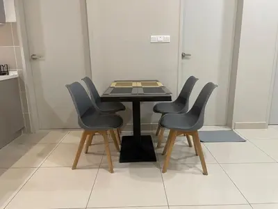 a table with four chairs in a room at Weekend House Trion in Kuala Lumpur