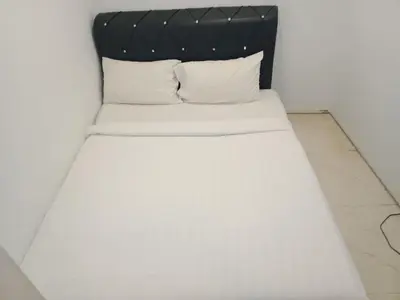 a white bed with a black headboard and white pillows at Vortex suites klcc by yana in Kuala Lumpur