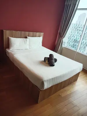 a teddy bear sitting on a bed in a bedroom at Vortex suites klcc by yana in Kuala Lumpur